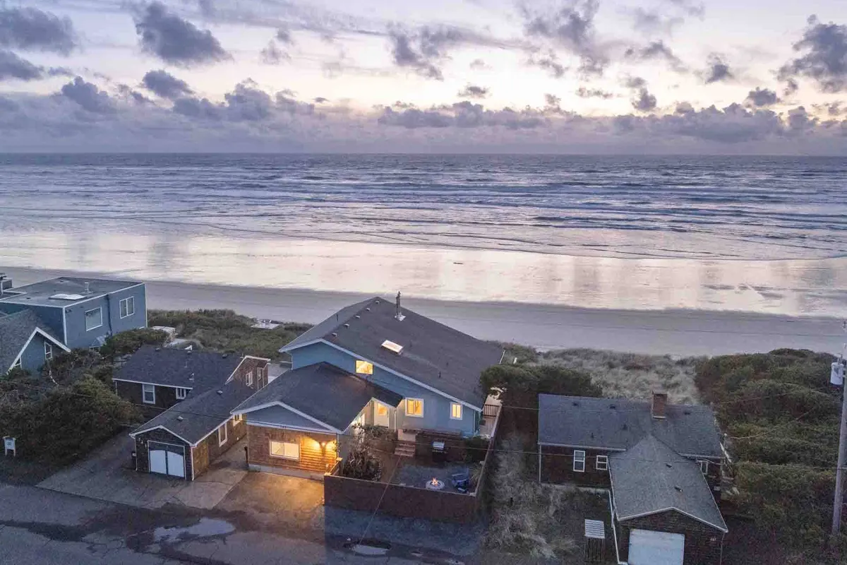 An exterior shot featuring a beachfront property set against a vibrant sunset sky, with sweeping ocean views and easy access to the sand. The scene conveys tranquility and the unique opportunity to enjoy the ocean's beauty right from the property.